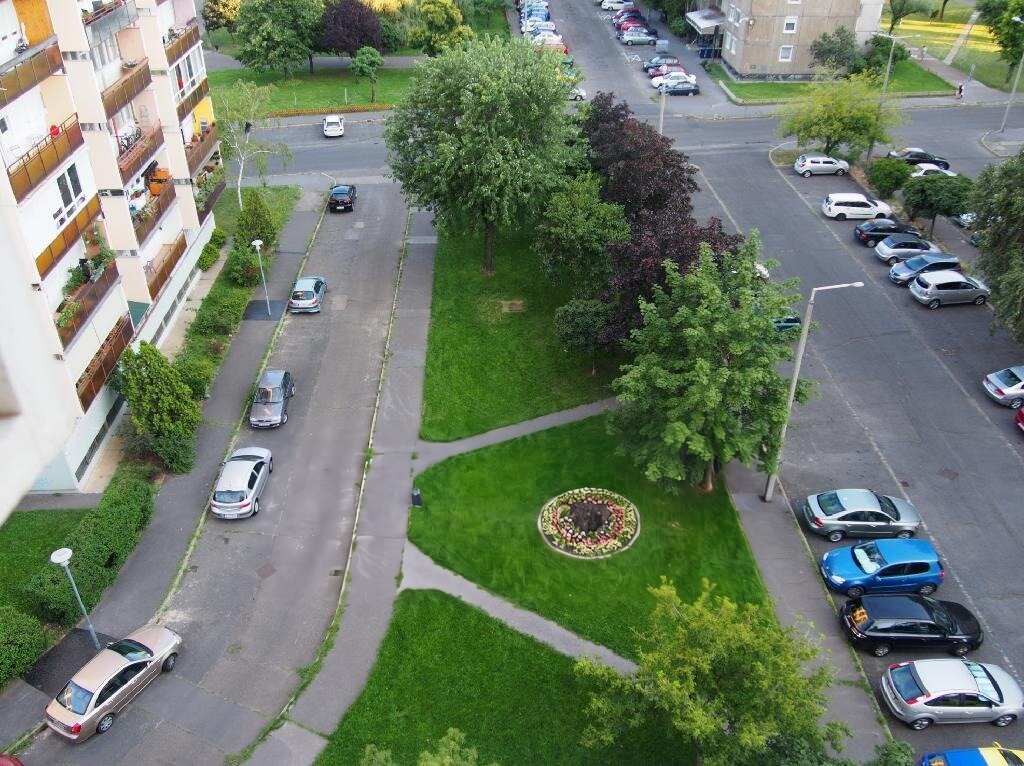 A ház környezete felülről: fásított zöldterületek, járdák és parkolók